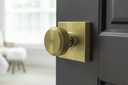 Close up of bedroom door with satin brass door knob.